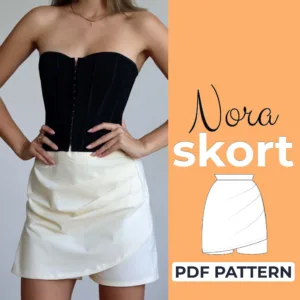 Girl wearing a black corset and a beige skort. On the left side it says Nora Skort pdf pattern